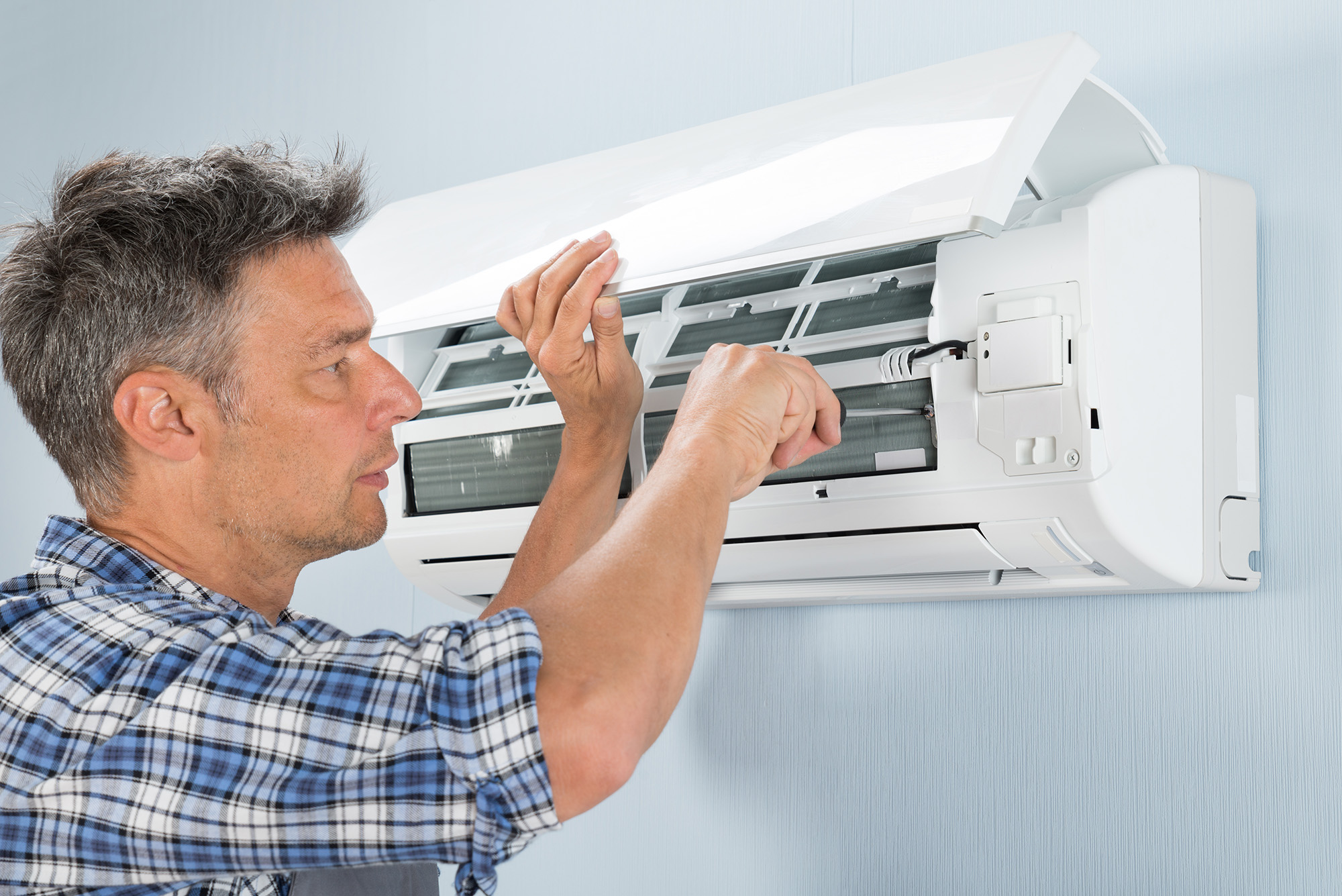 Portrait Of Mid-adult Male Technician Repairing Air Conditioner
